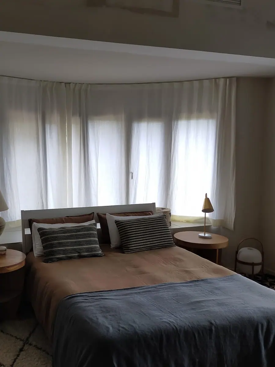 Dormitorio con cortinas en mirador y colcha a medida